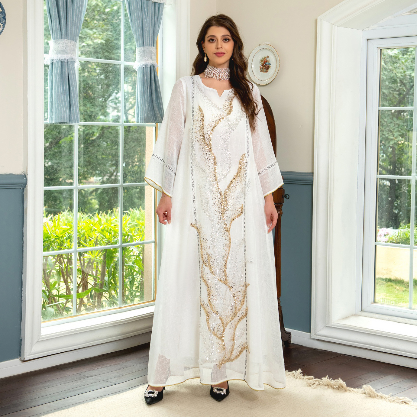 Indulge in the exquisite elegance of a white mesh jalabiya, adorned with beadwork embroidery, offering a lightweight and luxurious comfort