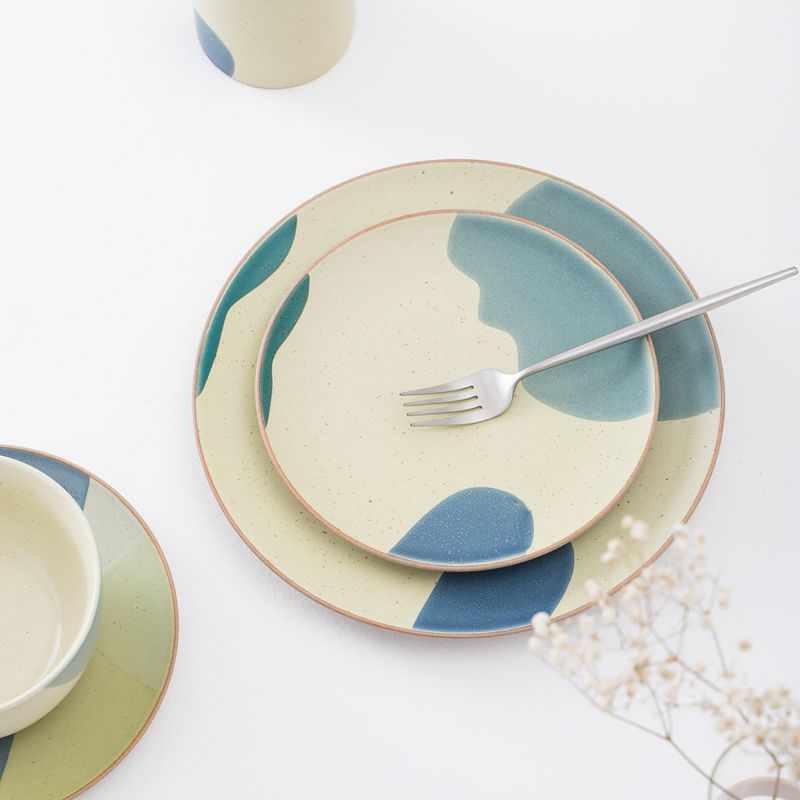Creative color-blocked ceramic dinner plate set with a rustic and textured finish. Perfect for serving and enjoying meals at home, this set includes bowls and plates for a complete dining experience