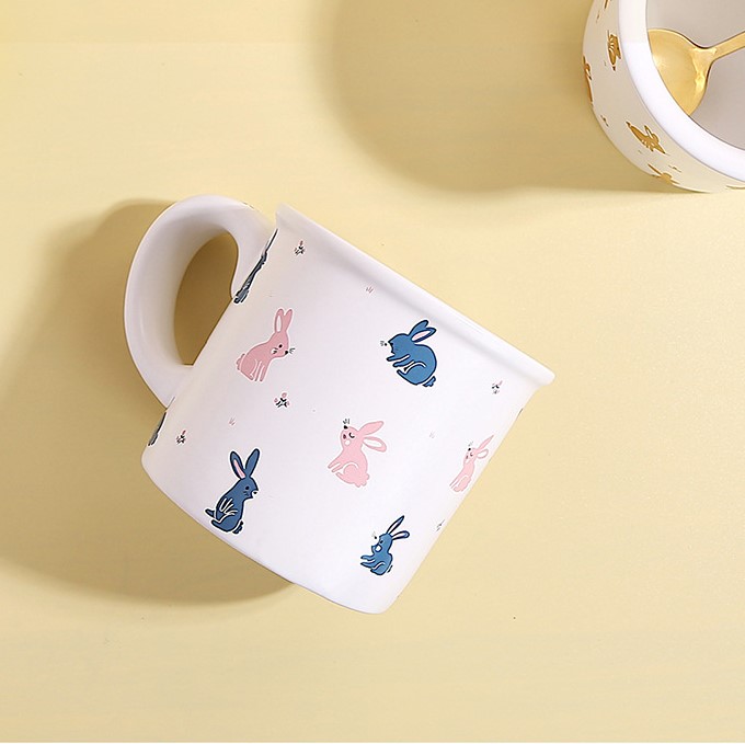Cartoon ceramic cup with a wide handle featuring an adorable white rabbit and an animal pattern